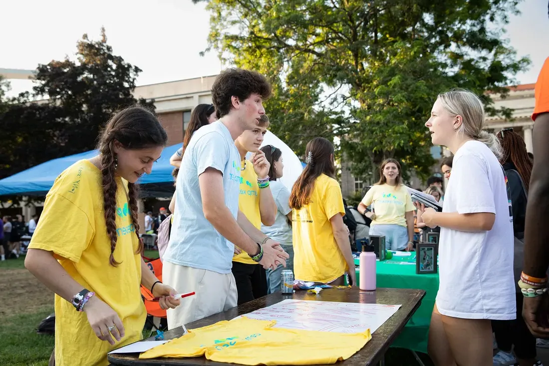 Students around table at involvement fair.